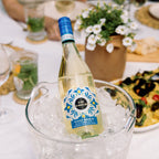 A bottle of Kim Crawford Pino Grigio in a wine bucket surrounded by ice with a blurred background
