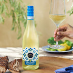 A bottle of Kim Crawford Pino Grigio with a person holding a wine glass 