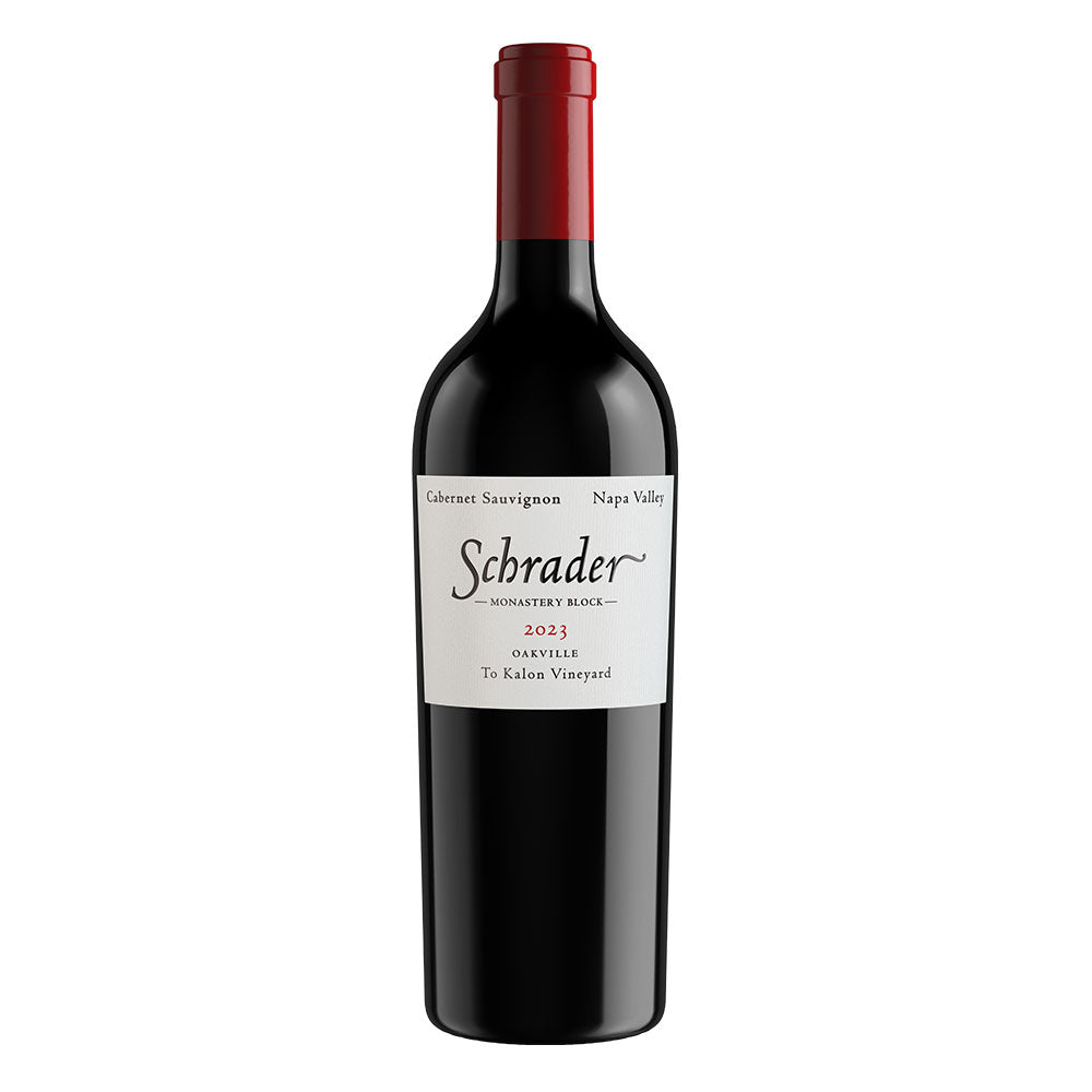 A bottle of Schrader Monastery Block 2023 Cabernet Sauvignon from Oakville, displayed on a clean white background. The bottle is dark glass with a red foil capsule and a white label featuring the black Schrader logo.