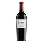A bottle of Schrader Monastery Block 2023 Cabernet Sauvignon from Oakville, displayed on a clean white background. The bottle is dark glass with a red foil capsule and a white label featuring the black Schrader logo.