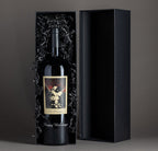 The Prisoner Red Blend etched with "Happy Holidays" in a black gift box on a gray background in the box