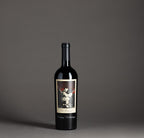 The Prisoner Red Blend etched with "Happy Holidays" in a black gift box on a gray background