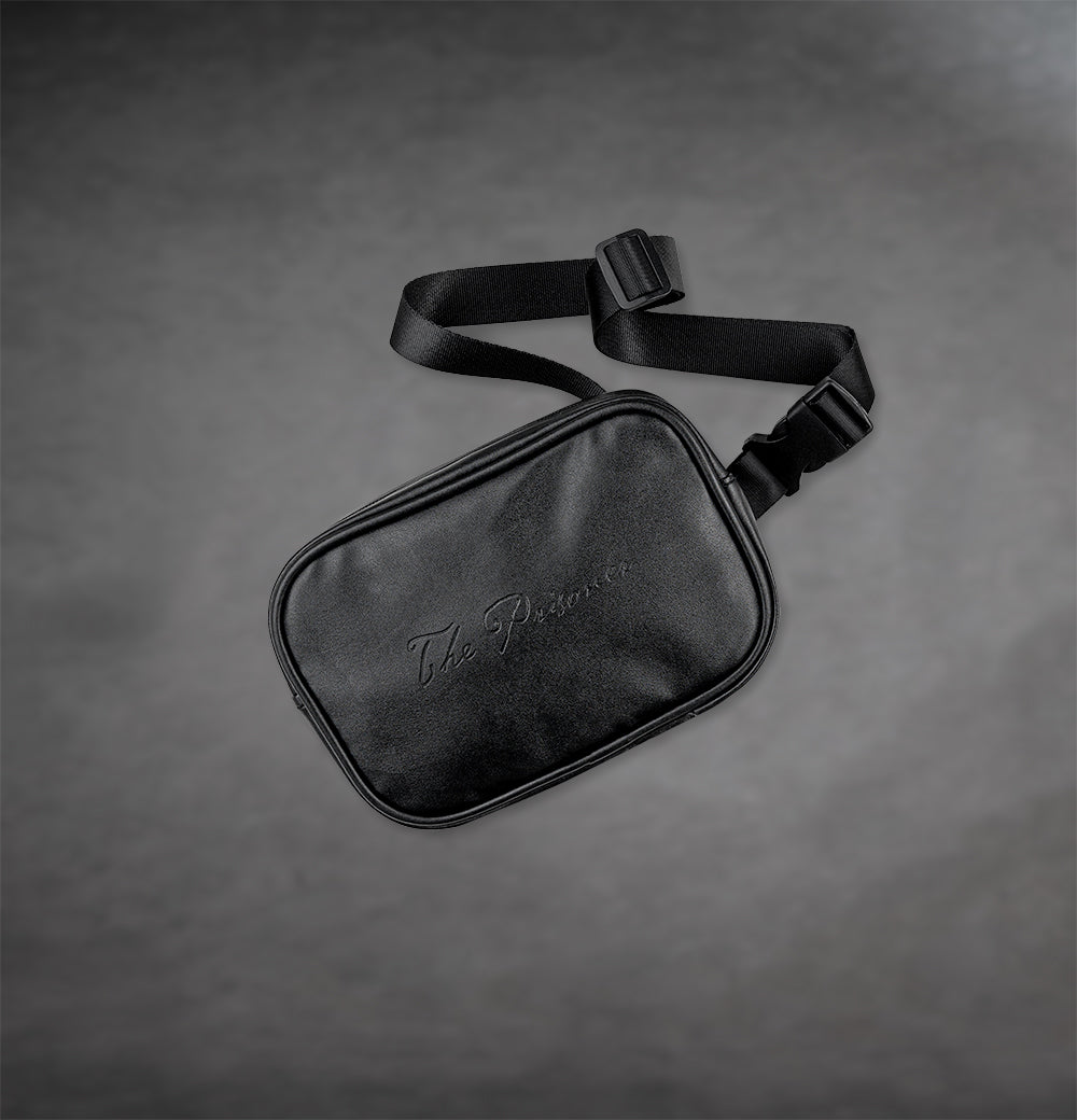 Leather belt bag with The Prisoner logo on the front on a gray background